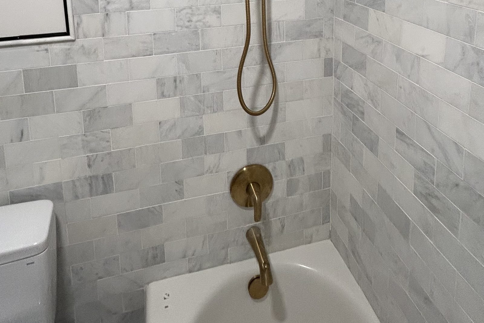 Marble tile shower with brass fixtures